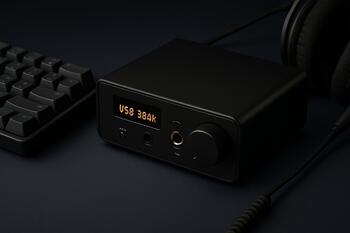 Compact desk DAC and headphone amp beside a keyboard